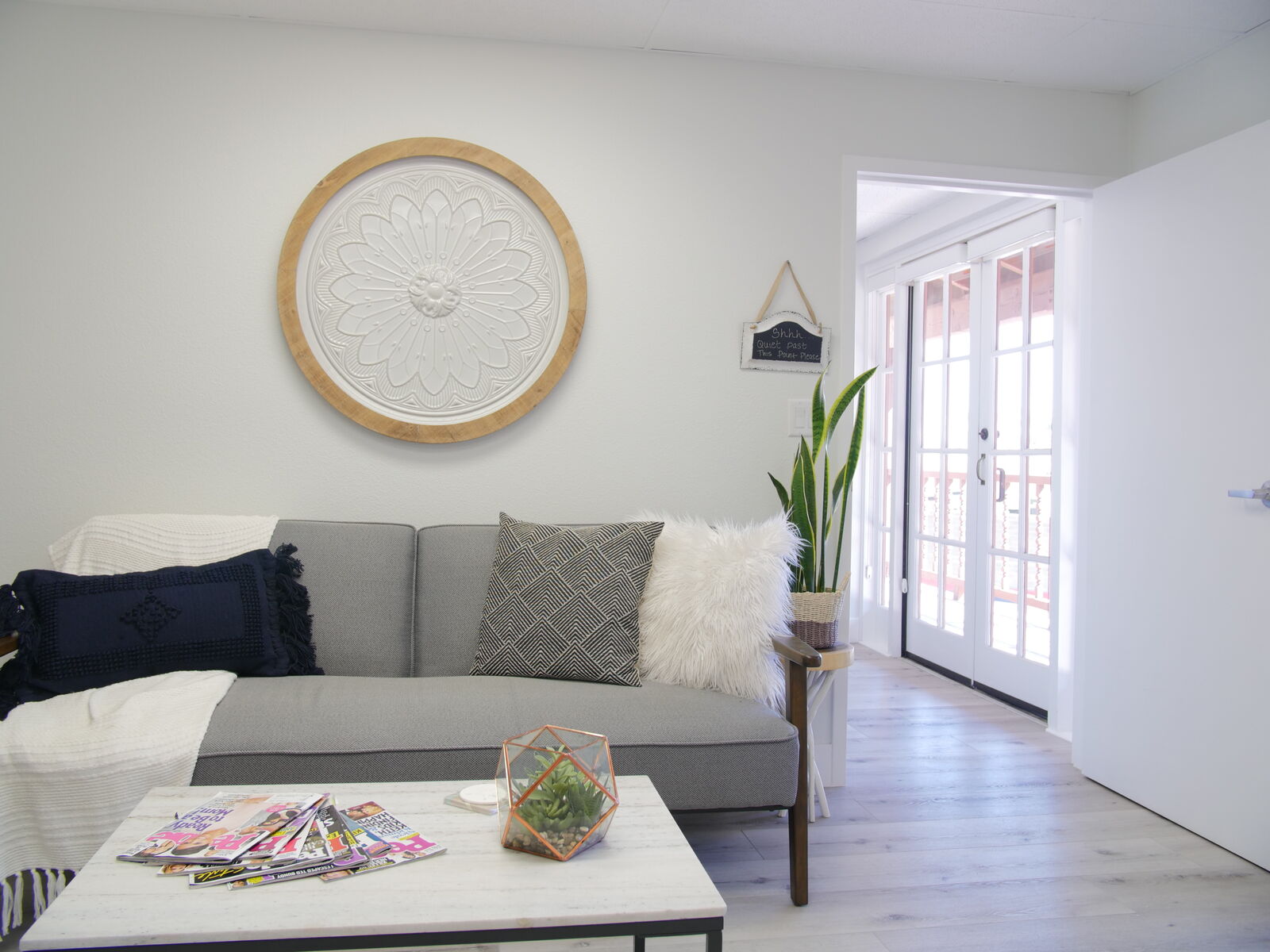 Lounge sofa with pillows beneath a round carved wall medallion